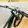 A close-up view of the handlebars of a green Reid E-Trail 2.0 MY23 electric bike displayed indoors. The bike is positioned against a light-colored wall with a wooden floor. The logo "Crazy Lenny's Electric Bikes" is visible at the top of the image. A close-up view of the handlebars of a green Reid E-Trail 2.0 MY23 electric bike displayed indoors. The bike is positioned against a light-colored wall with a wooden floor. The logo "Crazy Lenny's Electric Bikes" is visible at the top of the image.