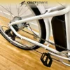 A white Serfas eDART 2023 350W electric bike with a 350W motor and visible battery pack is shown resting on a wooden floor. The image highlights the bike's rear wheel, gears, and pedal. The logo "Crazy Lenny's Electric Bikes" is prominently displayed at the top. A white Serfas eDART 2023 350W electric bike with a 350W motor and visible battery pack is shown resting on a wooden floor. The image highlights the bike's rear wheel, gears, and pedal. The logo "Crazy Lenny's Electric Bikes" is prominently displayed at the top.