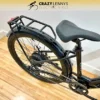 A close-up of the rear section of a black electric bike from Crazy Lenny's Electric Bikes, specifically the Reid Quest 1.0 MY23, showcasing the seat, rear wheel, chain, and a sturdy rear cargo rack. The image is set on a light wooden floor beneath a white wall. The store's logo is visible at the top. A close-up of the rear section of a black electric bike from Crazy Lenny's Electric Bikes, specifically the Reid Quest 1.0 MY23, showcasing the seat, rear wheel, chain, and a sturdy rear cargo rack. The image is set on a light wooden floor beneath a white wall. The store's logo is visible at the top.