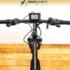 Top-down view of an EG Kyoto (Demo) electric bike's handlebar, featuring a digital display screen at the center. The brand "Crazy Lenny's Electric Bikes" is displayed at the top of the image. The bike, set for demo, rests on a wooden floor. Top-down view of an EG Kyoto (Demo) electric bike's handlebar, featuring a digital display screen at the center. The brand "Crazy Lenny's Electric Bikes" is displayed at the top of the image. The bike, set for demo, rests on a wooden floor.