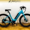 A bright blue electric bike with a black seat, black handlebars, and thick tires is placed against a white background. The bike has "Serfas eDASH" written on its frame. Above the bike, there is a logo and text reading "Crazy Lenny's Electric Bikes.