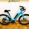 A bright blue electric bike with a sleek design rests on a wooden floor against a white wall. The text "Crazy Lenny's Electric Bikes" is displayed at the top of the image. The Serfas eDASH features a black saddle, handlebars, and tires. A bright blue electric bike with a sleek design rests on a wooden floor against a white wall. The text "Crazy Lenny's Electric Bikes" is displayed at the top of the image. The Serfas eDASH features a black saddle, handlebars, and tires.