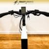 The image shows the handlebars and controls of a Serfas eDASH with a digital display screen in the center. "Crazy Lenny's Electric Bikes" is written at the top, indicating the store or brand. The bike, equipped with Serfas accessories, is indoors on a hardwood floor with a plain white background. The image shows the handlebars and controls of a Serfas eDASH with a digital display screen in the center. "Crazy Lenny's Electric Bikes" is written at the top, indicating the store or brand. The bike, equipped with Serfas accessories, is indoors on a hardwood floor with a plain white background.