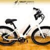 A white Serfas eDASH electric bike with black accents is displayed against a plain white background. The logo "Crazy Lenny's Electric Bikes" is seen at the top center. The wooden floor contrasts with the Serfas eDASH's color, which features a step-through frame and black tires. A white Serfas eDASH electric bike with black accents is displayed against a plain white background. The logo "Crazy Lenny's Electric Bikes" is seen at the top center. The wooden floor contrasts with the Serfas eDASH's color, which features a step-through frame and black tires.