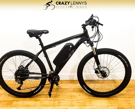 A sleek black electric bike, the EG Kyoto, with thick tires and a sporty design is displayed against a white background. The bike has a battery pack attached to the frame, disc brakes, and an ergonomic seat. The text "Crazy Lennys Electric Bikes" is at the top of the image.