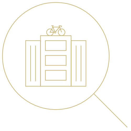 Minimalistic line art of a building with three horizontal layers, a bicycle on the roof, and a magnifying glass icon encompassing the building, giving emphasis to it. This "about us" illustration is in a monochromatic gold color scheme on a black background.