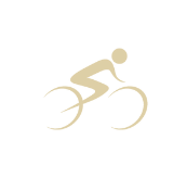 A simple, solid gold silhouette of a person riding a bicycle. The design is minimalistic, with curves representing the wheels and the rider depicted in a racing position.