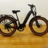 Aima-Big-Sur-Fat-Tire-1024x768 Black electric bike with tan tires on wood floor.
