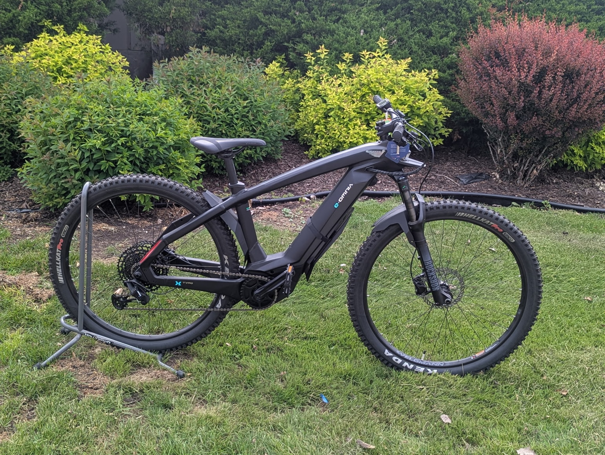 Electric mountain bike parked on grass.
