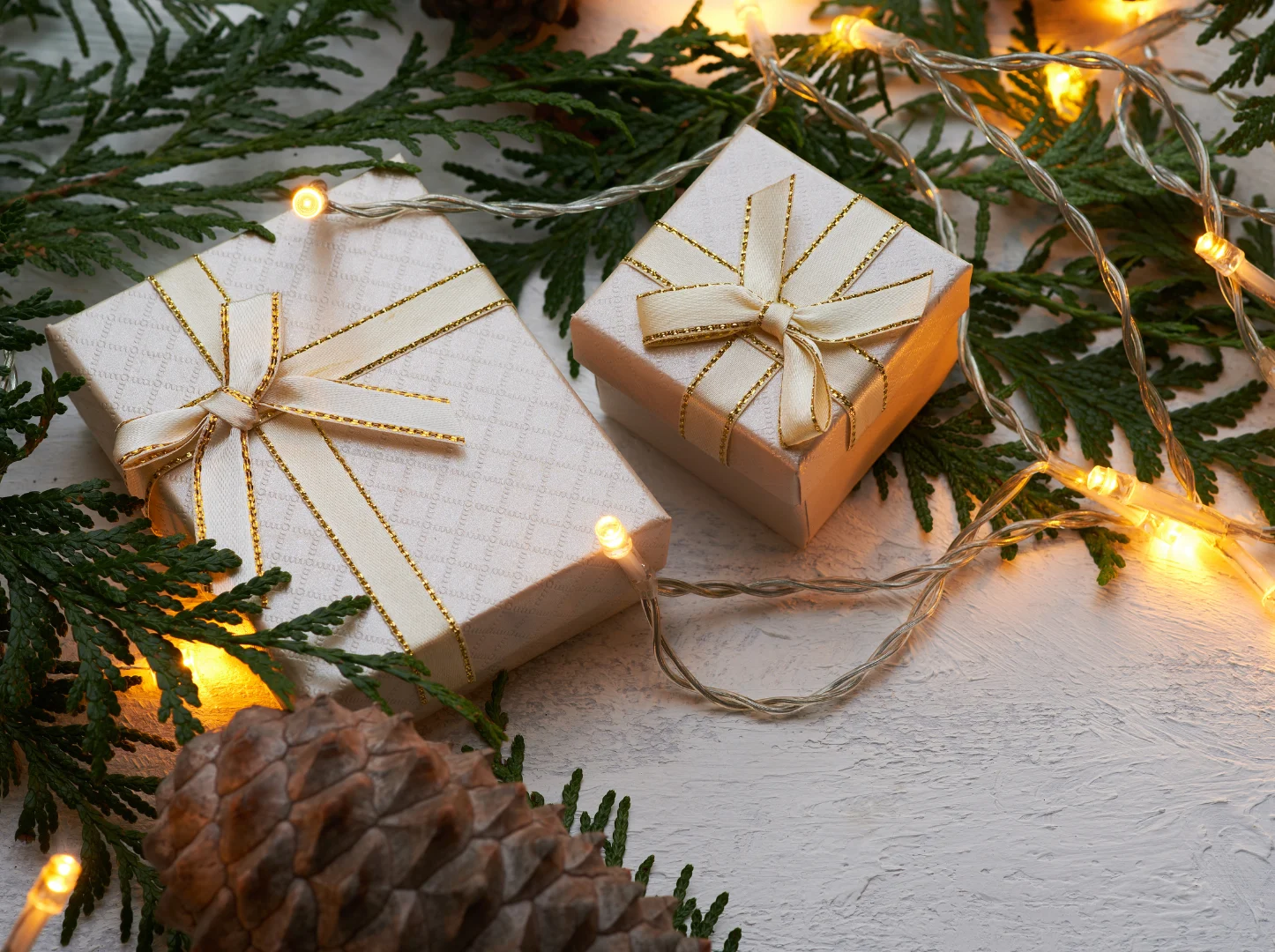 Festive gift boxes with lights and greenery.
