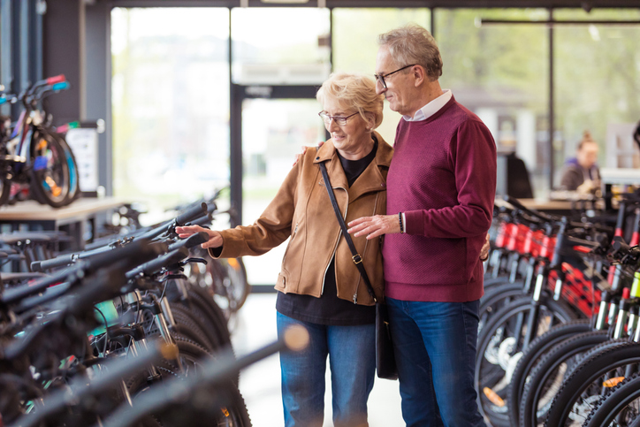 Senior couple shopping for bicycles in store.