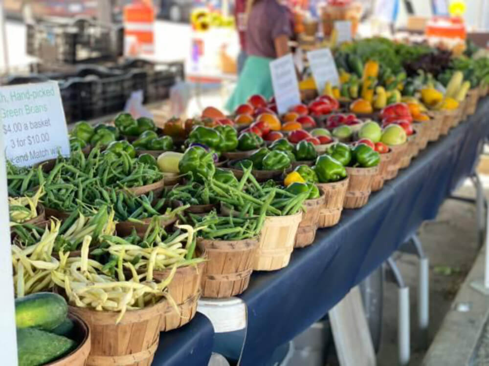 Fresh vegetables displayed at outdoor market stall.