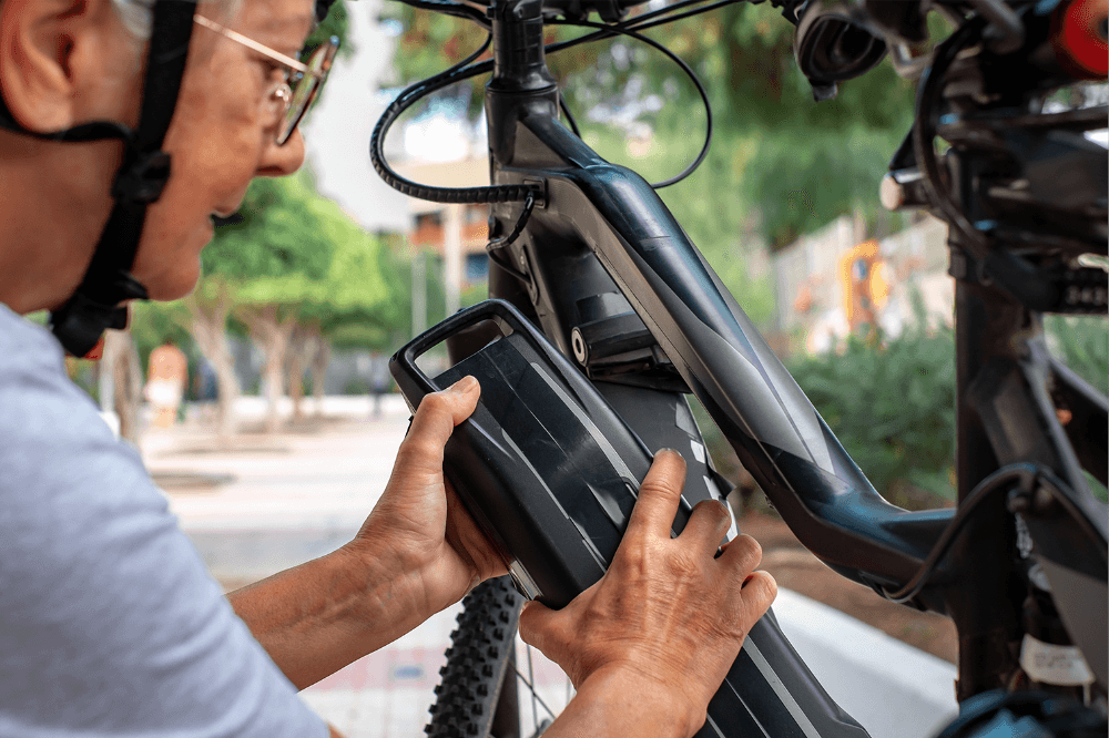 Person inserting battery in electric bike.