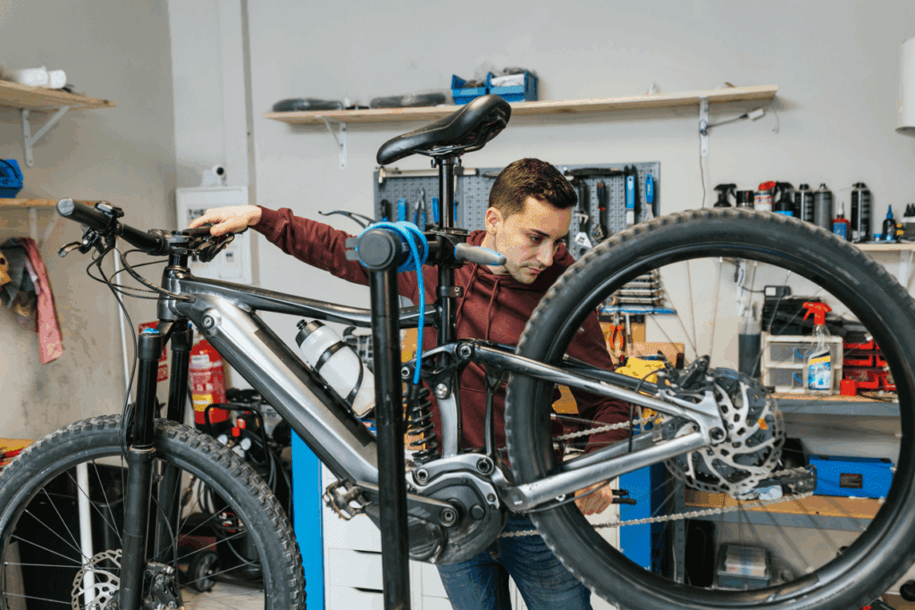 Man repairing bicycle in workshop.