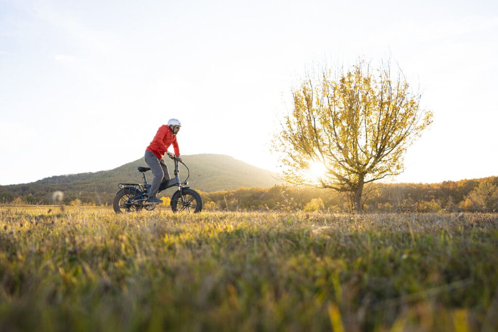 Cyclist rides bike at sunset in countryside