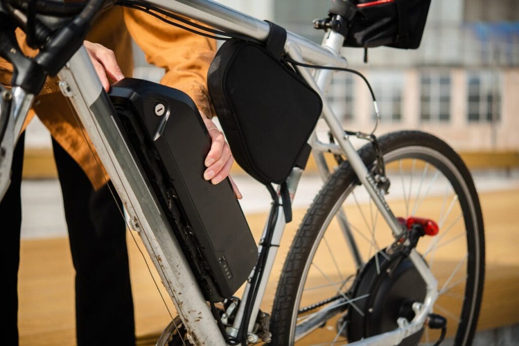 Person installing battery on electric bike frame.