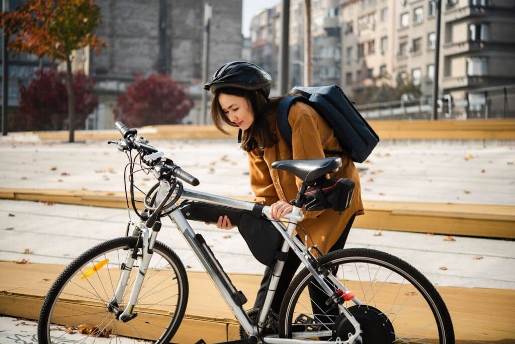 Woman securing bicycle battery outdoors
