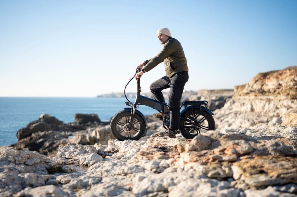 Person biking on rocky cliff by the sea
