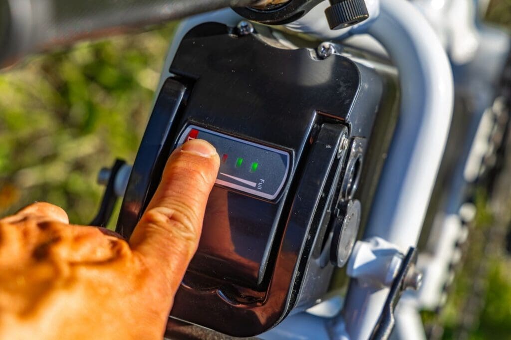 Finger pressing electric bike battery power button