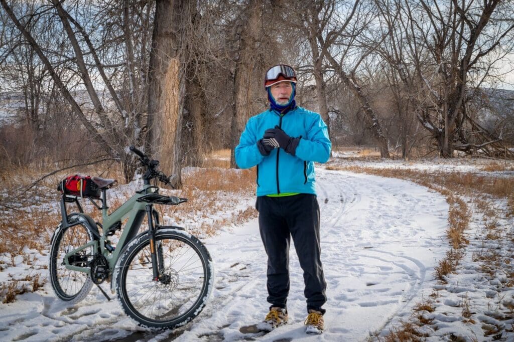 Man with bicycle on snowy forest path