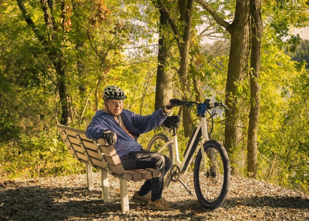 Man resting with bicycle in forest