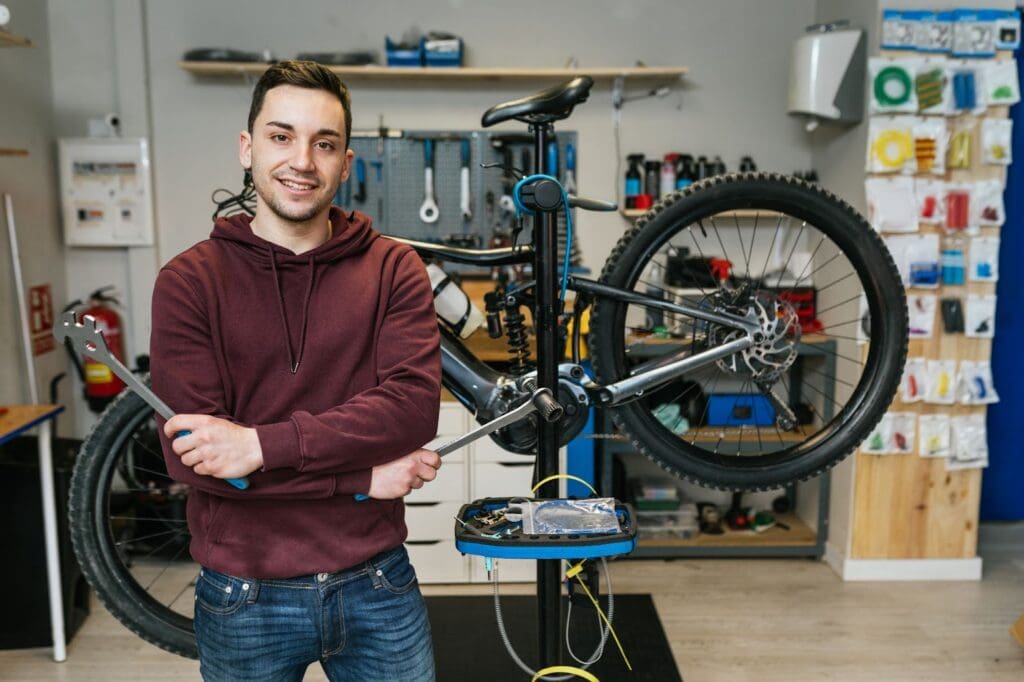 Man smiling in a bicycle repair shop