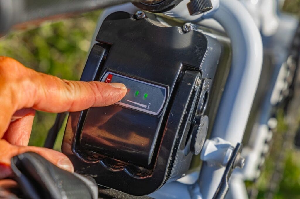Hand pressing electric bike battery indicator.