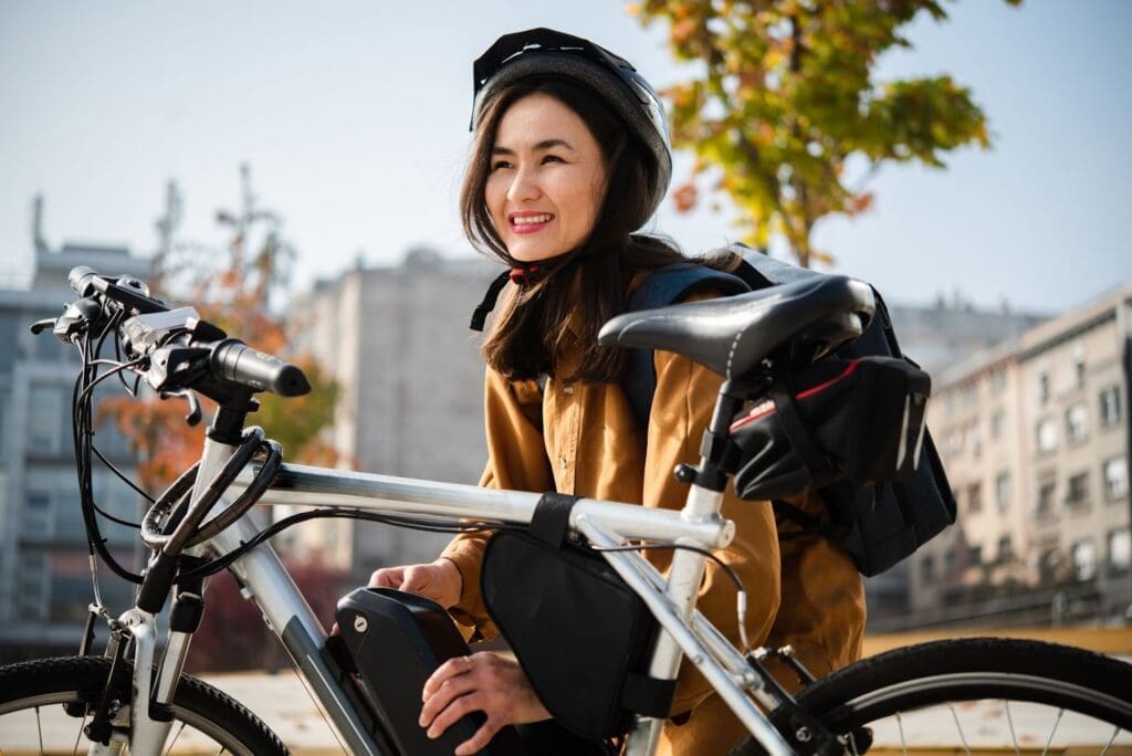 Woman smiling with bicycle outdoors