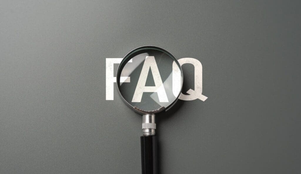 FAQ magnified by a glass on gray surface.