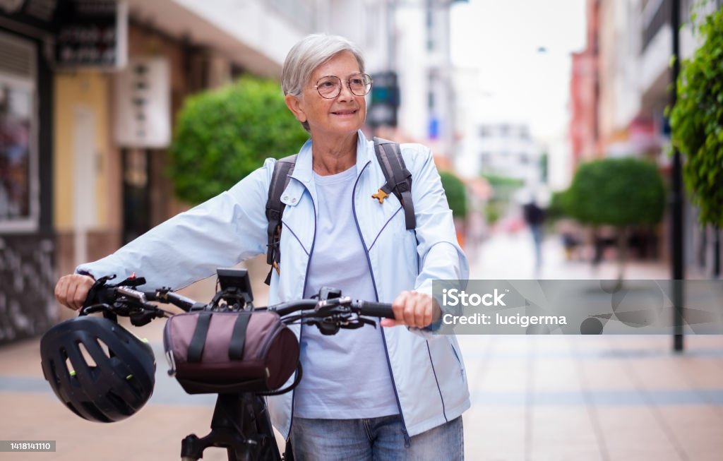 Smiling woman with bicycle on city street