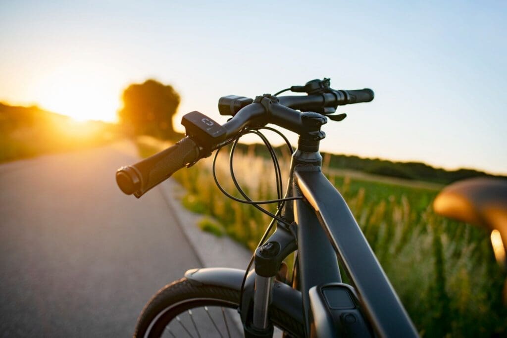 Bicycle handlebars on rural road at sunset