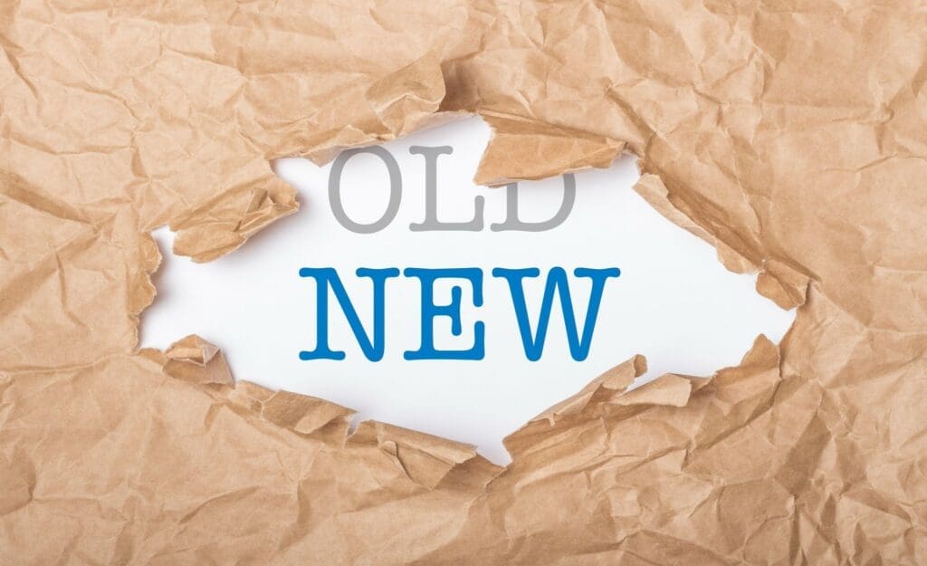 Torn paper revealing the word NEW