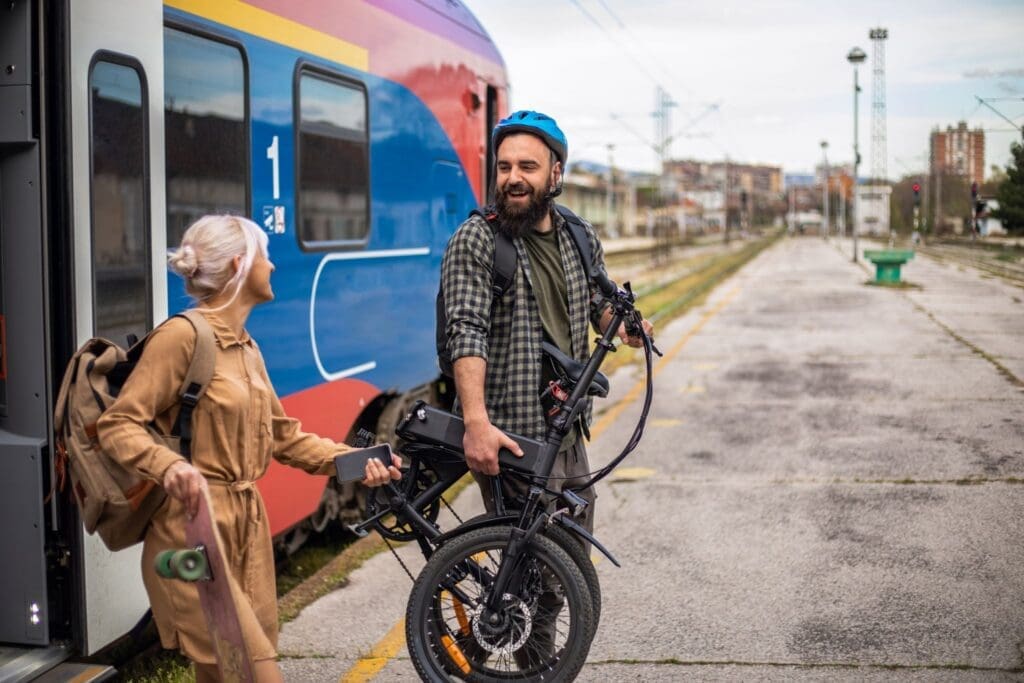 Couple with bike and skateboard at train station