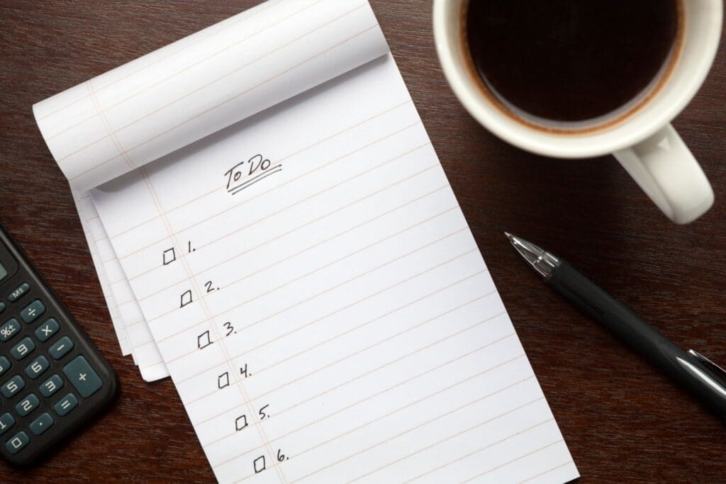 To-do list notebook with coffee and calculator
