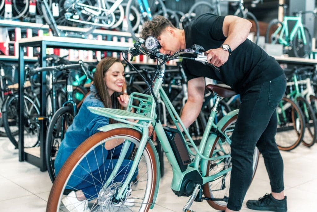 Two people examining electric bicycle in bike shop
