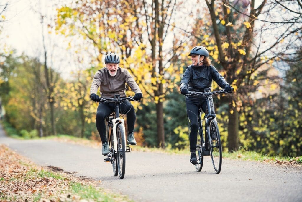 Couple cycling on autumn park trail
