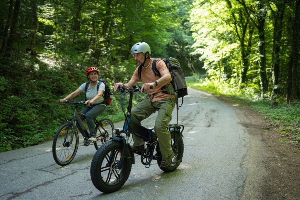 Two cyclists riding on forest road