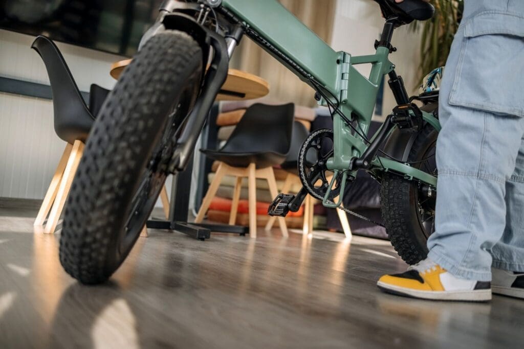 Green electric bike indoors with rider nearby