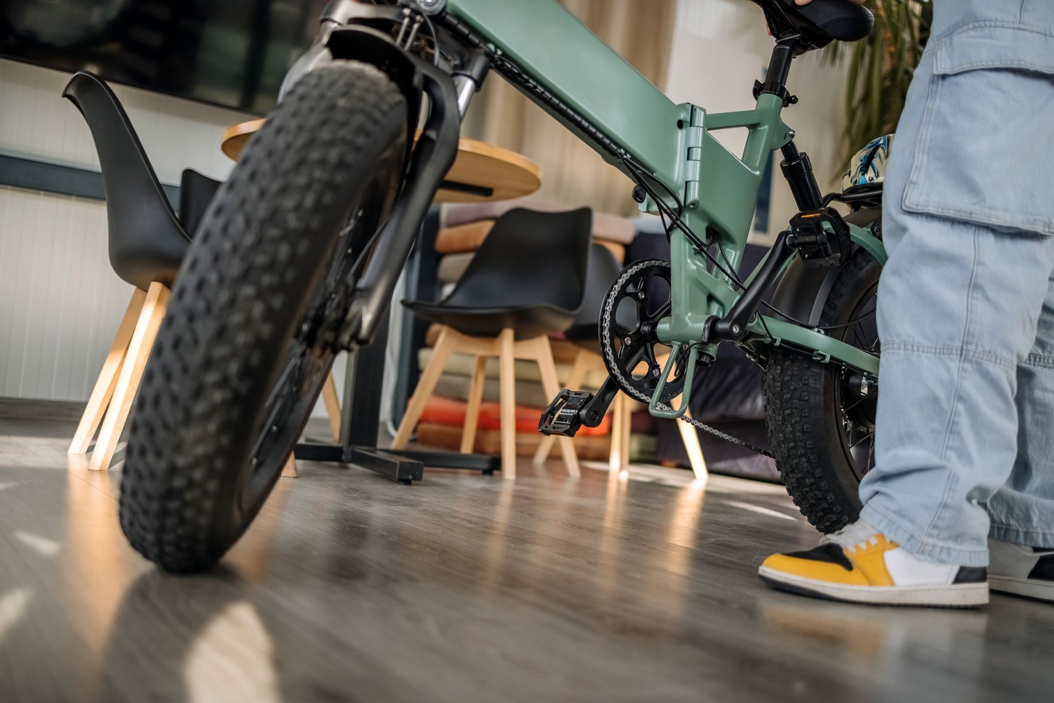 Green electric bike indoors with rider nearby