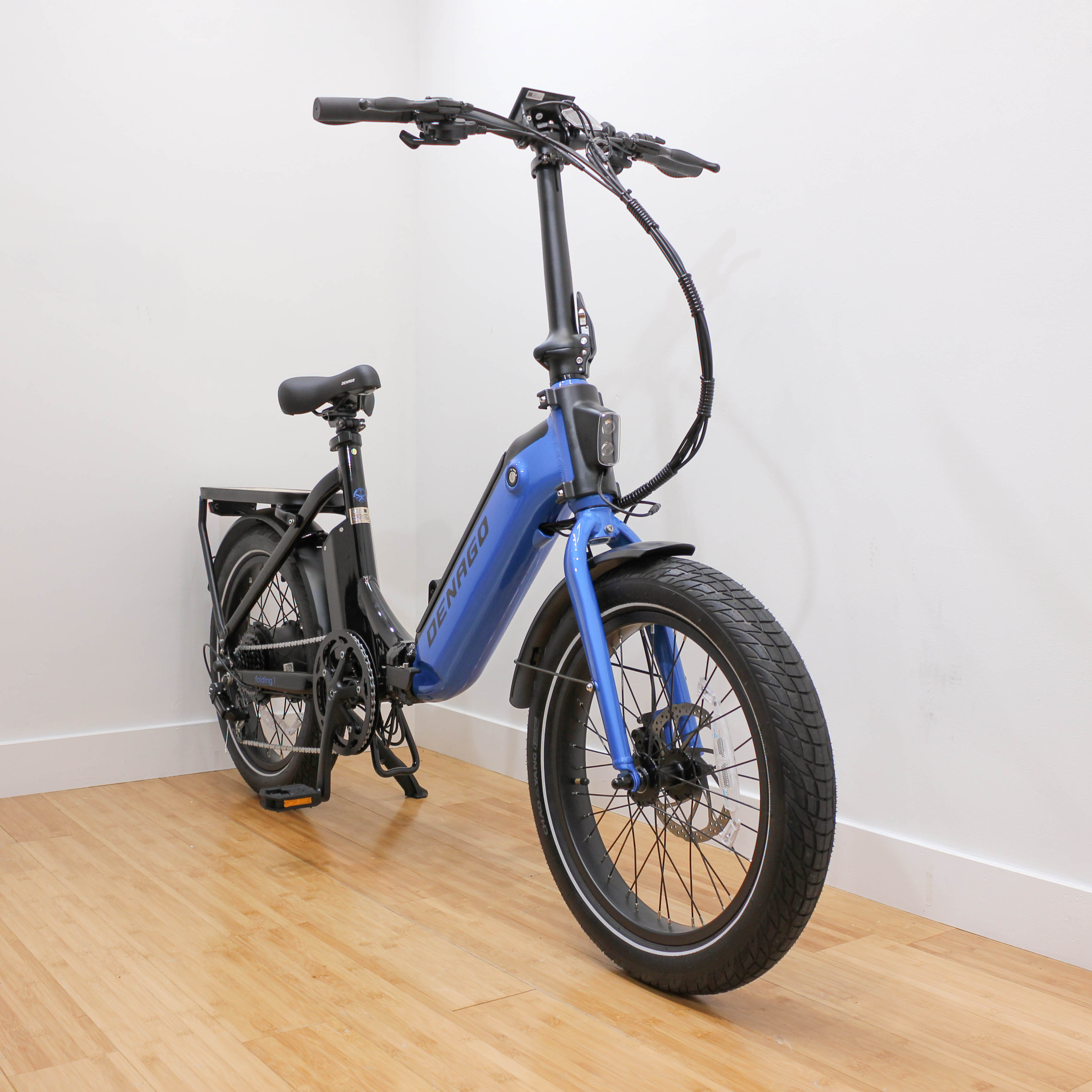 Blue folding electric bicycle indoors on wooden floor