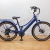 Retrospec - Beaumont Rev Plus - Classic Blue - 1 Profile Blue step-through electric bicycle with rear rack indoors