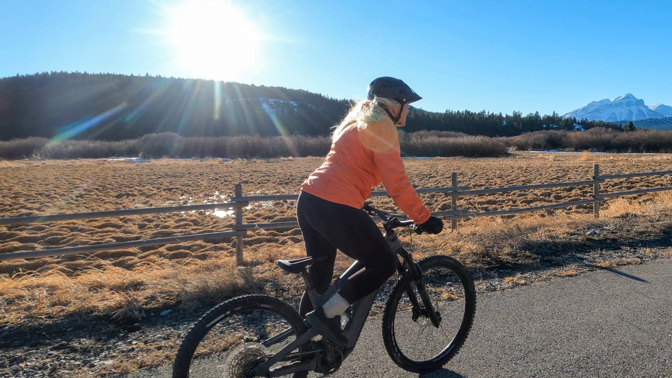 Woman cycling on sunny mountain trail