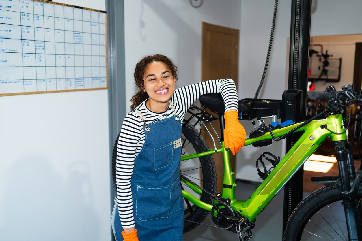 Smiling mechanic beside bright green mountain bike
