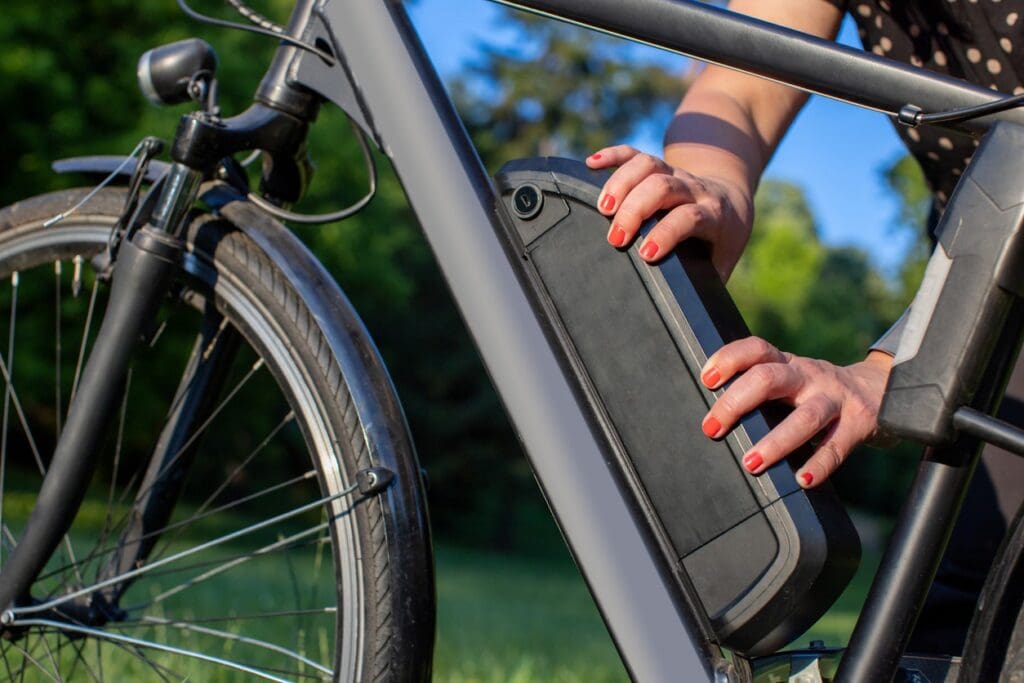 Person removing battery from an electric bicycle